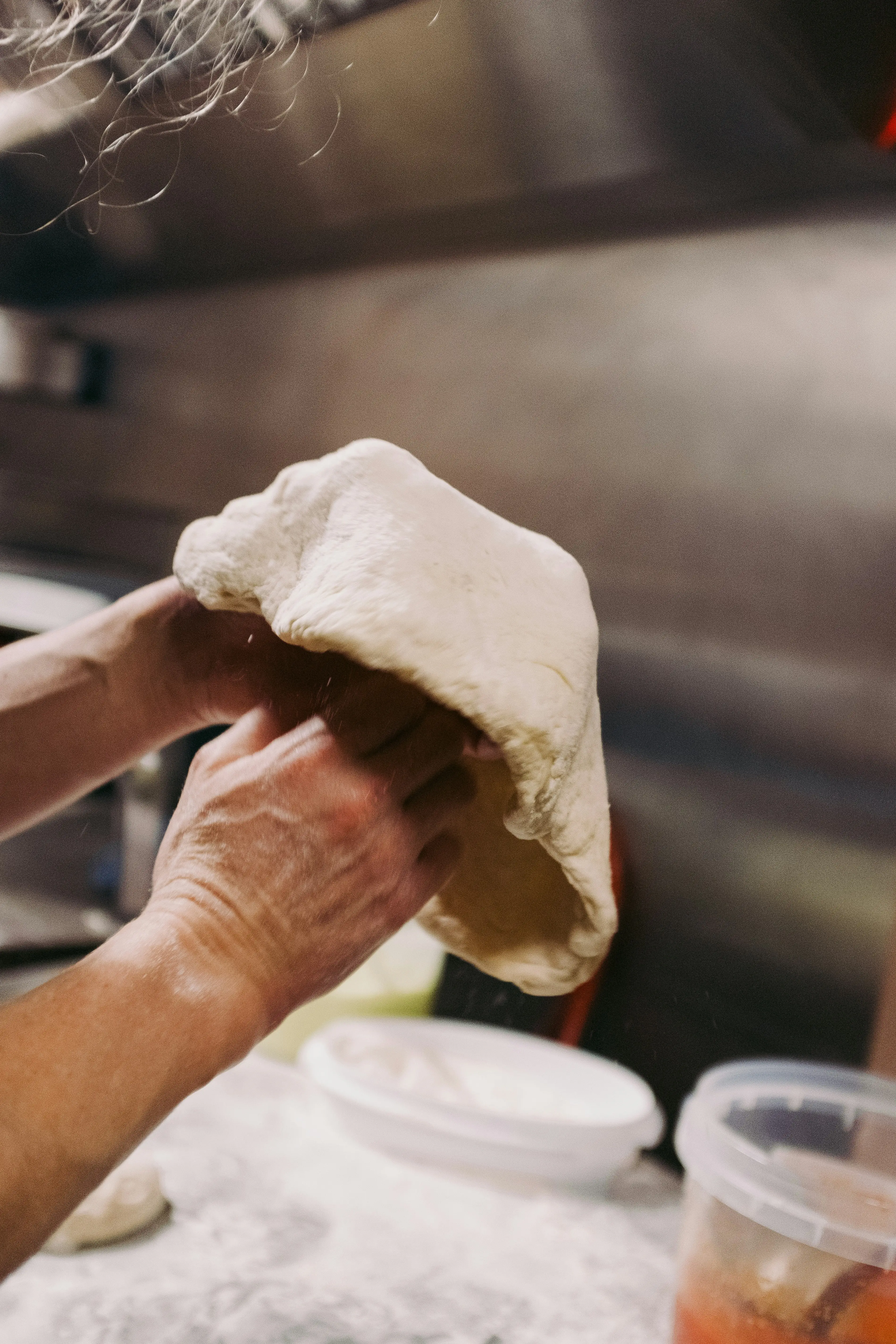 Pizzateig wird in der Küche mit den Händen geformt